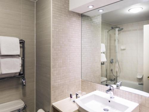 a bathroom with a sink and a mirror at Mercure Daventry Court Hotel in Daventry