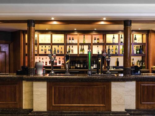 a bar with a lot of bottles of alcohol at Mercure Daventry Court Hotel in Daventry