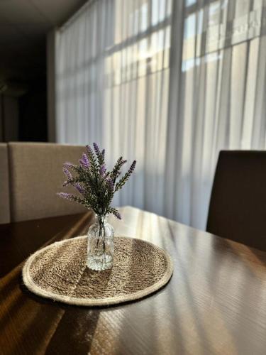 a vase with purple flowers sitting on a table at Prenoćište Stanica in Bosanska Krupa