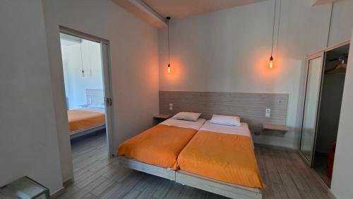 a bedroom with a bed with orange sheets and a mirror at Ianos Bay in Lefkada Town