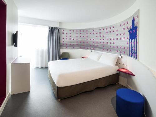 ポール・ヴァンドルにあるIbis Styles Collioure Port Vendresの白いベッドと青い椅子のある寝室