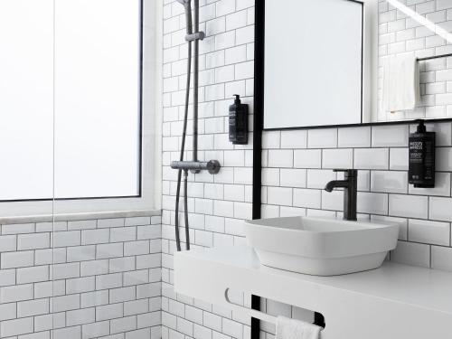 a white bathroom with a sink and a shower at Ibis Styles Lisboa Centro Liberdade NE in Lisbon