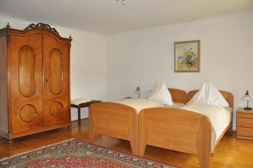 a bedroom with a wooden bed and a wooden cabinet at Gästehaus Benediktinerstift Göttweig - Bed & Breakfast Monastery in Furth