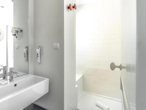 a white bathroom with a sink and a shower at Ibis Styles Lisboa Centro Liberdade NE in Lisbon