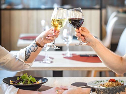 two people are holding glasses of wine at Ibis Styles Lisboa Centro Liberdade NE in Lisbon