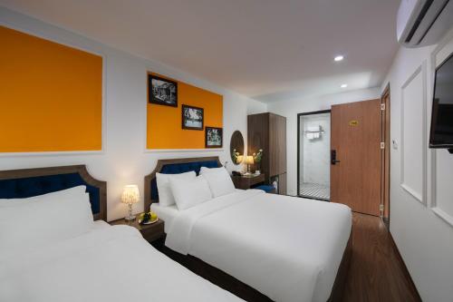 a hotel room with two beds and a television at Hanoi Southgate Hotel & Spa in Hanoi