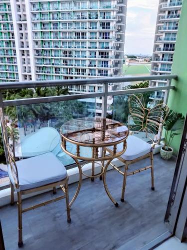 a balcony with a glass table and two chairs at Azure Staycation by Jeric in Manila
