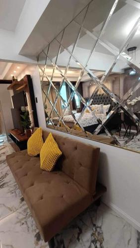 a living room with a couch and a glass wall at Azure Staycation by Jeric in Manila