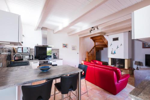 a kitchen with a wooden table and red chairs at Ty Ker'embruns, charmant penty au cœur de L'Armor Pleubian in Pleubian