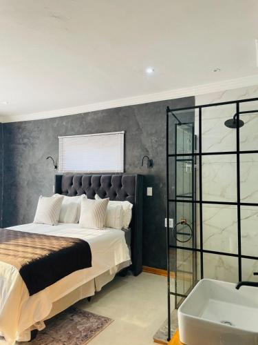 a bedroom with a large bed and a bath tub at Kruger Place in Mokopane