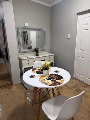 a white table and chairs in a room with a mirror at Nampaton Farm in Drummond
