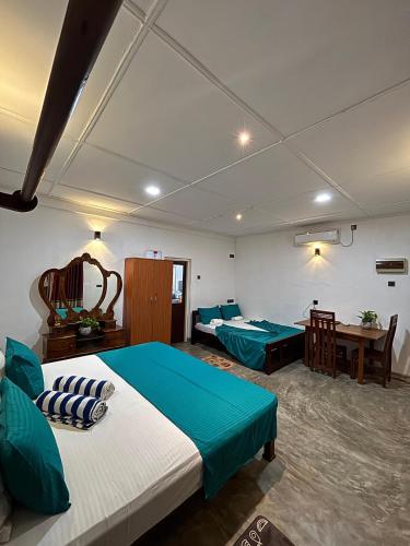 una habitación de hotel con dos camas y una mesa en New mahi mahi villa, en Dikwella