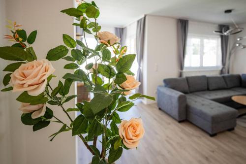 a vase with orange roses in a living room at EHM Elegantes Design Apartment zwischen Linz&Wels in Pucking