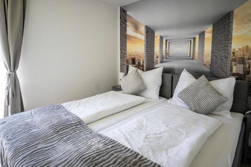 a bedroom with a large white bed with a painting on the wall at EHM Elegantes Design Apartment zwischen Linz&Wels in Pucking
