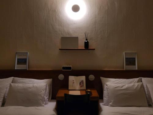 a room with a bed with a light on the wall at jeonju hotel book and type in Jeonju