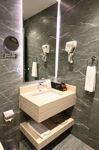 a bathroom with a sink and a mirror at فندق امان أبها - المعالي in Abha