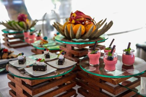 a buffet with desserts and fruit on plates on a table at Diamonds Thudufushi Maldives Resort & Spa in Thundufushi