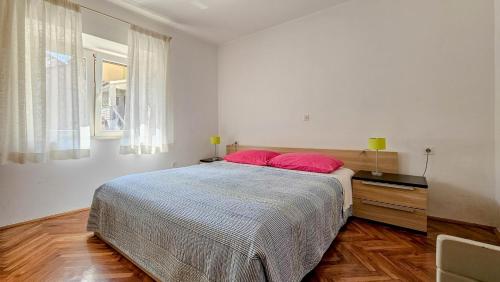 a bedroom with a bed with red pillows on it at Mesic in Novigrad Istria