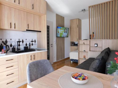 a kitchen and living room with a couch and a table at Aurora Lux in Vrnjačka Banja
