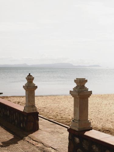 two stone barriers on a beach with the ocean at Serene Vita Retreat in Phumĭ Ŏng Char