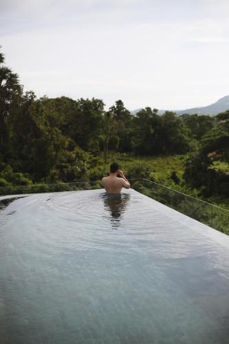 a man sitting in a pool of water at Serene Vita Retreat in Phumĭ Ŏng Char