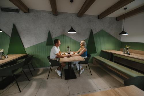 a man and woman sitting at a table in a restaurant at Na Orave dobre na Orave PENZIÓN SEVERKA! in Oravská Lesná
