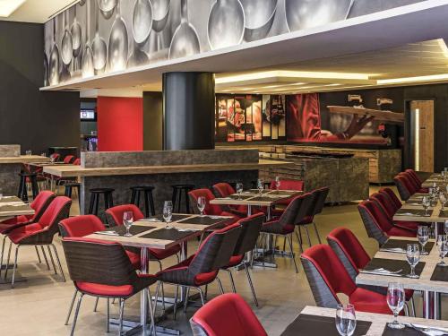 a restaurant with tables and chairs and a bar at ibis Santos Valongo in Santos