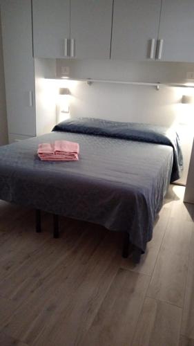 a bedroom with a bed with a blue blanket at L'Aurora Porto Torres in Porto Torres