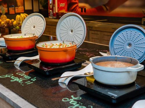 three bowls of food sitting on a counter at ibis Santos Valongo in Santos