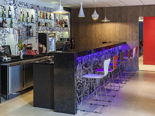 a bar with purple stools in a restaurant at ibis Santos Valongo in Santos