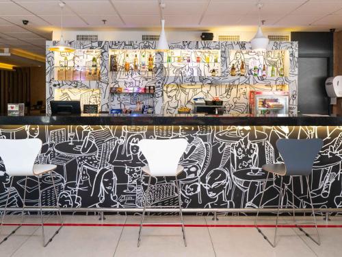 a bar with a wall covered in graffiti at ibis Santos Valongo in Santos