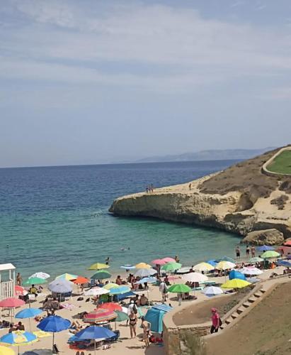 a group of people standing on a beach with umbrellas at L'Aurora Porto Torres in Porto Torres