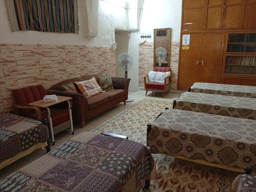 a room with three beds and a couch and a couch at Soufan Guest HOUSE in Nablus