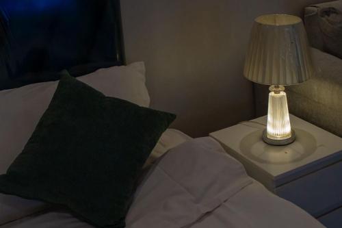 a bed with a night stand with a lamp on a table at الكهوف النجدية السليمانية in Riyadh
