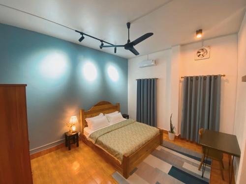 a bedroom with a bed and a desk in it at Casa Primera in Luang Prabang