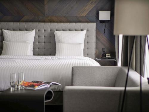 a bedroom with a bed and a couch and a chair at Pullman Riga Old Town in Rīga