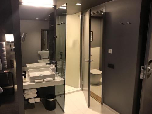 a bathroom with a sink and a toilet and a mirror at Pullman Riga Old Town in Rīga