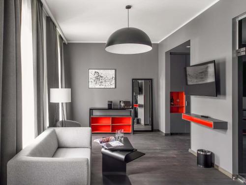 a living room with a couch and a table at Pullman Riga Old Town in Rīga