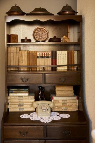 a book shelf filled with books and a telephone at Apartments "Old house Mustafic" in Bar