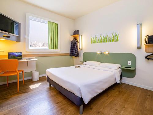 a hotel room with a bed and a desk at ibis budget SP Frei Caneca in Sao Paulo