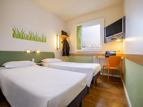 a hotel room with two beds and a window at ibis budget SP Frei Caneca in Sao Paulo