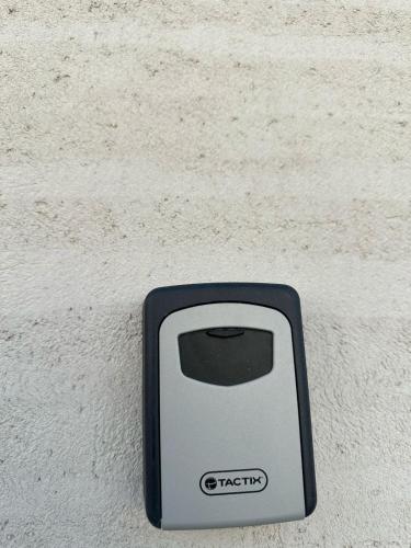 a black and white cell phone sitting on a wall at Grand Sweet in Unayzah