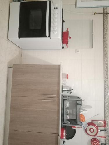 a kitchen with a microwave and a cabinet at حمودي شقق مجهزة للكراء مرحبا بالجميع in Skikda