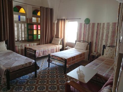 a room with three beds and a window at Soufan Guest HOUSE in Nablus