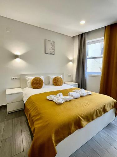 Un dormitorio con una cama grande con una manta amarilla. en Almada Downtown 201, en Oporto