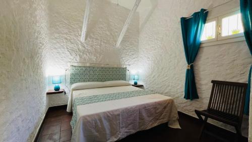 a bedroom with a bed and a chair in a room at Ventus Auster in Olbia