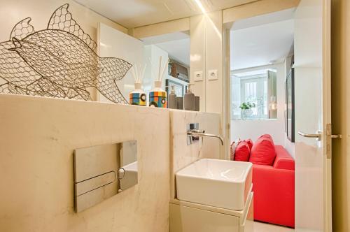 a bathroom with a sink and a red couch at BmyGuest - Alfama Boutique Apartment in Lisbon