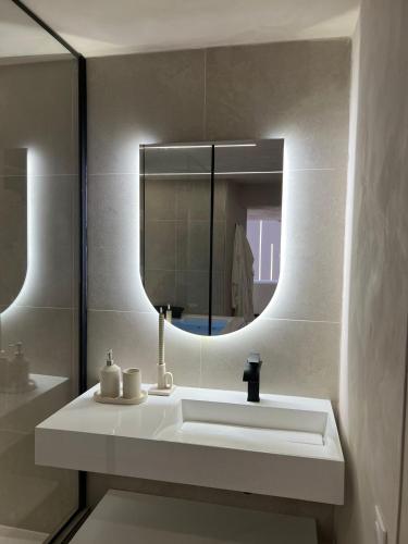 a bathroom with a white sink and a mirror at crystal stay in Melun