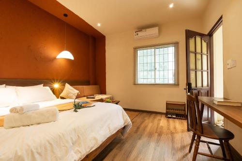 a bedroom with a large white bed and a desk at PINhome in Ho Chi Minh City