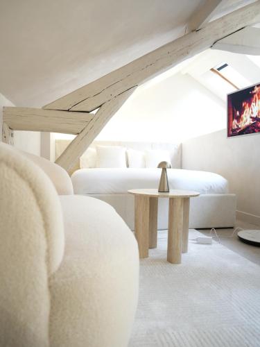 a living room with two beds and a table at crystal stay in Melun